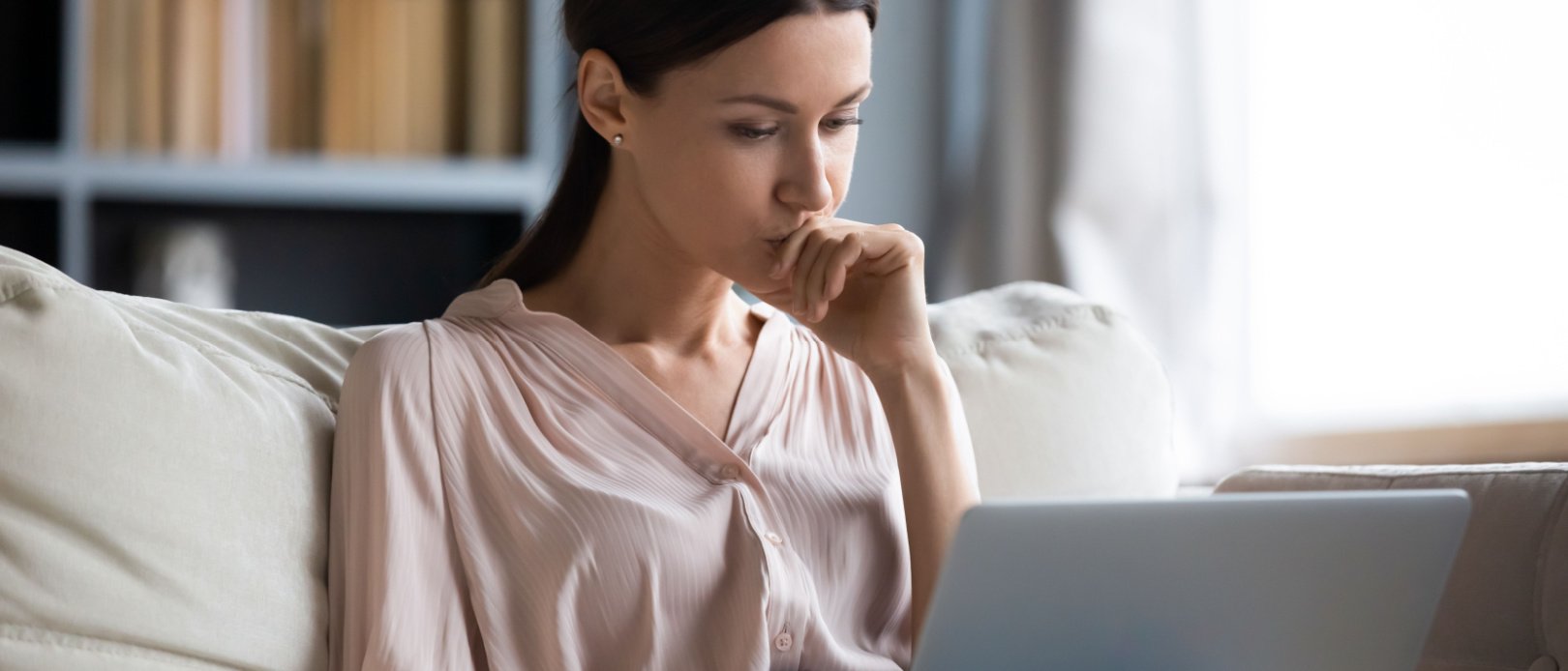 Close up thoughtful upset woman looking at laptop screen